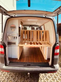 the back end of a van with wooden shelves in it's cargo area and wood flooring