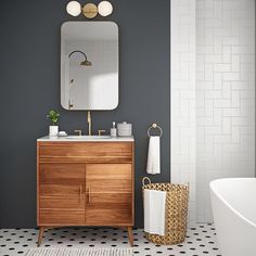 a bathroom with a sink, mirror and bathtub in the middle of the room