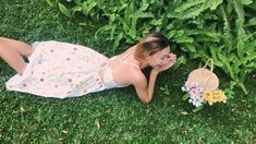 a woman laying on the ground next to plants