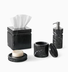 black marble bathroom accessories including soap dispenser, toilet paper holder and cup