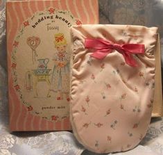 an opened book with a pink bow on it next to a baby's diaper