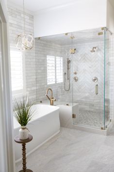 a bathroom with white tile and gold fixtures