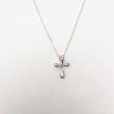 A gorgeous tiny and simple, Sterling Silver cross hangs delicately from a Sterling Silver chain. This small, slightly puffy cross has softly rounded edges and is super smooth. Available in Sterling Silver or Gold Vermeil. A beautiful keepsake piece of jewelry or gift for a baptism or dedication that will last a lifetime. - Pendant - Sterling Silver or Gold Vermeil - 13mm x 9mm (Made in the USA) - Chain + components - Sterling Silver or 14K Gold-Fill - Clasp - Sterling Silver or 14K Gold-filled l Affordable Silver Cross Pendant Jewelry, Simple Everyday Cross Pendant Necklace, Dainty Cross Necklace For Everyday, Simple Everyday Cross Necklace, Simple Cross Necklace With Delicate Chain, Minimalist Cross Charm Necklace With Delicate Chain, Silver Cross Necklace With Delicate Chain, Sterling Silver Cross Necklace With Delicate Chain, Delicate Silver Cross Necklace