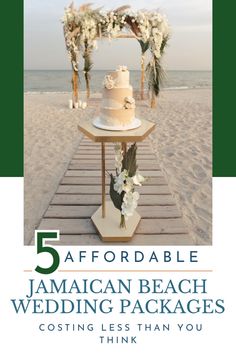 a wedding cake sitting on top of a wooden table next to the ocean with flowers