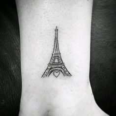 a black and white photo of the eiffel tower on someone's foot