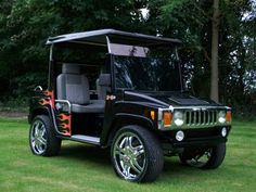 a black jeep with flames painted on it's front and side doors is parked in the grass