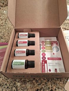 an open box with four bottles of essential oils in it sitting on a counter top