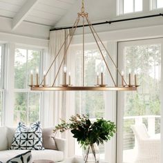 a living room filled with furniture and a chandelier hanging over it's windows