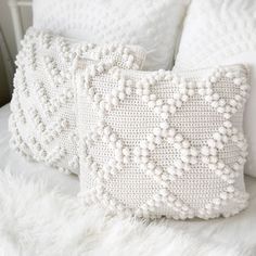 two white pillows sitting on top of a bed