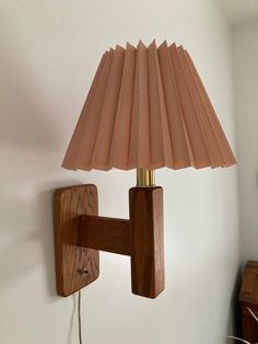 a lamp that is on the wall next to a wooden frame and a light fixture