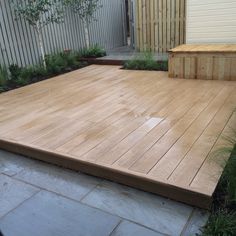 a wooden deck in the middle of a garden