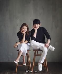 two people sitting on chairs posing for a photo