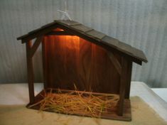 a small wooden birdhouse with hay in it's nest and lights on the roof