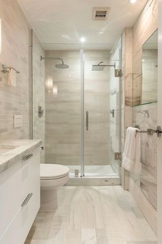 a bathroom with a walk in shower next to a toilet