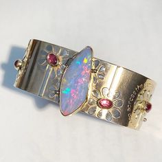 "14K WIDE Opal Cuff Bracelet, Botanical Solid Gold Bracelet, Hand Forged 14K Yellow Gold Artwork Cuff, Emerald Cuff, Rubellite Tourmaline From any and every angle this baby is a LUXURY DREAM come true🌈As I was working on this piece I fondly began to refer to it as \"The opal garden\"...so that shall be her name! 🌺 The center stone is a 9.1 carat Brazilian opal with 5/5 complete rainbow fire at every angle. I cannot even capture half of it in photos - this is a \"must see in person to believe i One Of A Kind Bangle Bracelet, Wearable Art Style, Handmade Heirloom Cuff Bracelet For Gift, Artisan Cuff Bracelet For Weddings, Artisan Wedding Cuff Bracelet, Opal Cuff Bracelet, Flower Cuff Bracelet, Gold Artwork, Solid Gold Bracelet, Luxury Gifts For Her