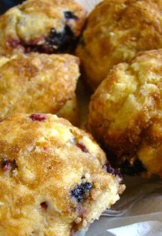 some blueberry muffins are sitting on wax paper