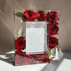 a glass frame with red roses in it