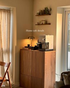 a living room with a couch, chair and coffee maker in front of a window