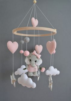 a baby mobile with an elephant and hearts hanging from it