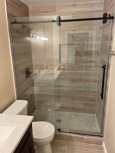 a bathroom with a walk in shower next to a white toilet and sink under a mirror