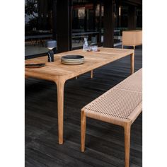 a wooden table with two chairs and a plate on it next to an empty bowl