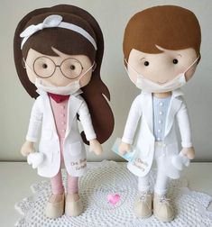 two dolls are dressed in white lab coats