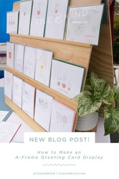 some cards are sitting on top of a stand with a potted plant in the background