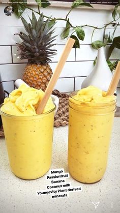 two jars filled with banana pudding next to a pineapple