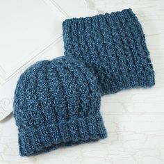 two blue knitted hats sitting next to each other