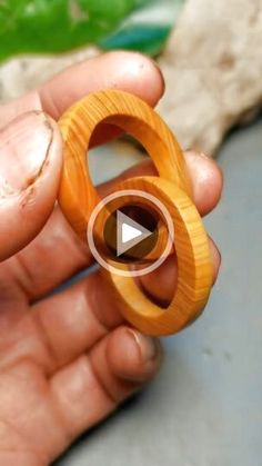 a person holding a wooden ring in their hand with the video showing how to make it