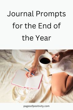 a woman sitting on top of a bed next to a cup of coffee and notebook