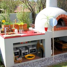 an outdoor pizza oven in the middle of a garden