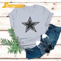 a t - shirt with a black star on the front, and blue jeans next to it