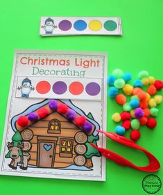 a christmas light decorating activity with pom - poms on a green background