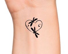 a heart shaped tattoo with two dragonflies on it