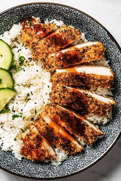 a plate filled with rice, meat and cucumber slices on top of it