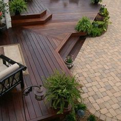 a deck with steps leading up to an outdoor living room and dining area in the background