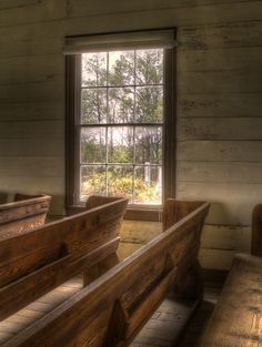 an empty church with wooden pews and windows