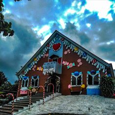 a house decorated with candy canes and decorations on the front porch, stairs leading up to it