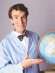 a man in a bow tie holding up a globe