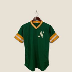 a green and yellow jersey with the letter n on it, hanging from a hanger