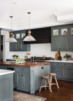 an image of a kitchen setting with gray cabinets and wood flooring in the middle