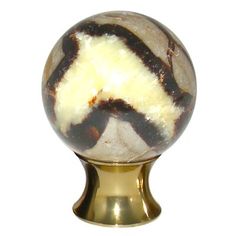 a marble ball on a gold base with a moustached mustache painted on it