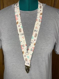 Various pattered white background lanyards. Each lanyard has a lobster clip and key ring in antique brass. These lanyards are made from sewing scraps and may contain seamed pieces of the same fabric. Lanyards are ~20 inches long x 1 inch wide. Fabric Lanyard, Badge Holders Lanyard, Badge Holders, Cow Print, Key Ring, Lanyard, Antique Brass, 1 Inch, White Background