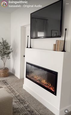 a living room with a fireplace and tv mounted on the wall