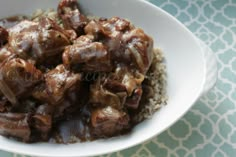 a white bowl filled with meat and rice