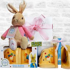 a stuffed rabbit sitting on top of a wooden box filled with books and other items