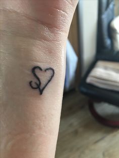 a small heart tattoo on the wrist