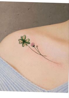 a woman's shoulder with three clovers on it