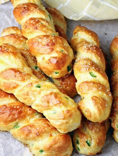 several pieces of bread with cheese and herbs on them sitting next to a baguette